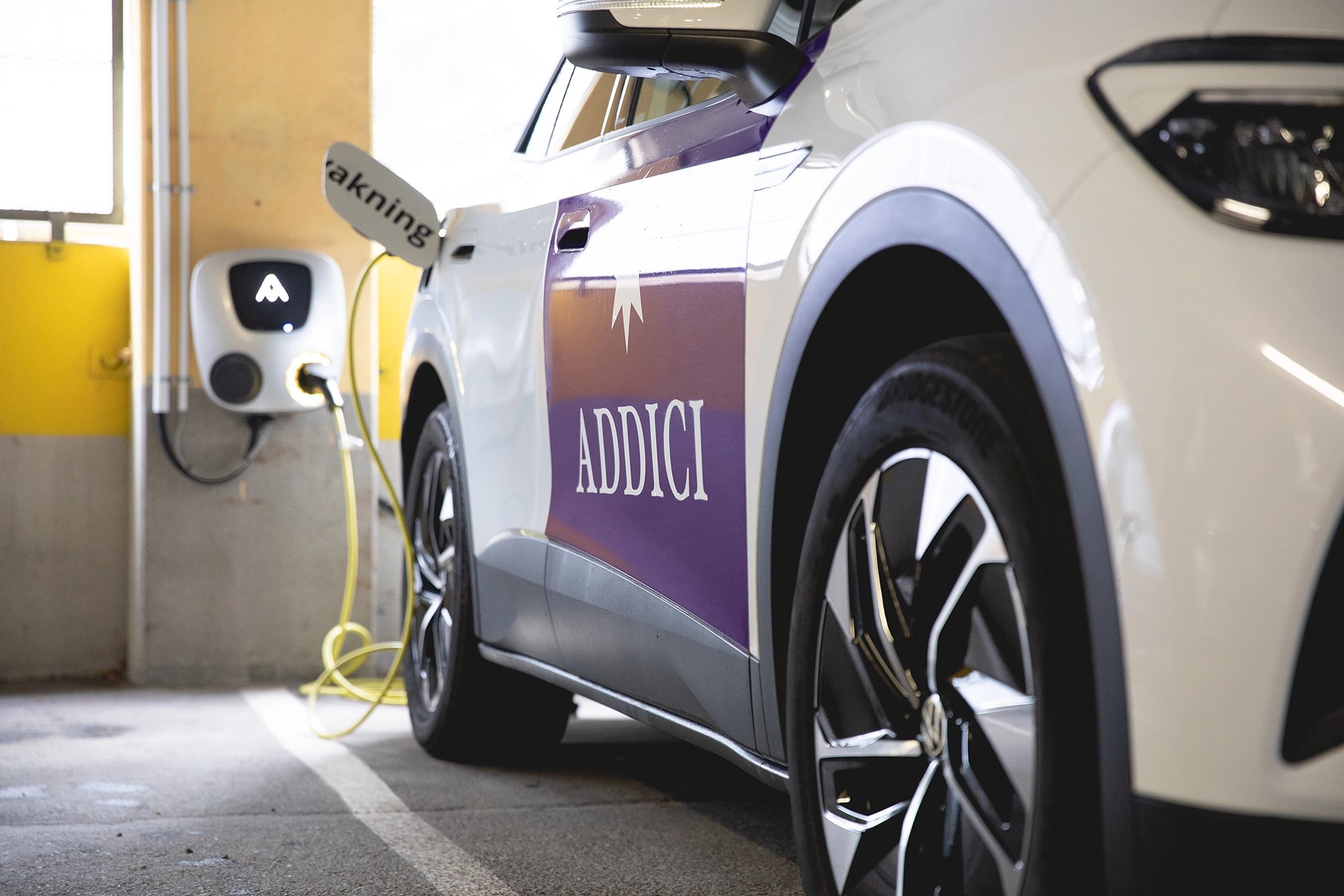 En av Addicis elbilar laddas i ett garage.