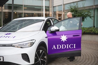 Väktare på Addici som står vid bil