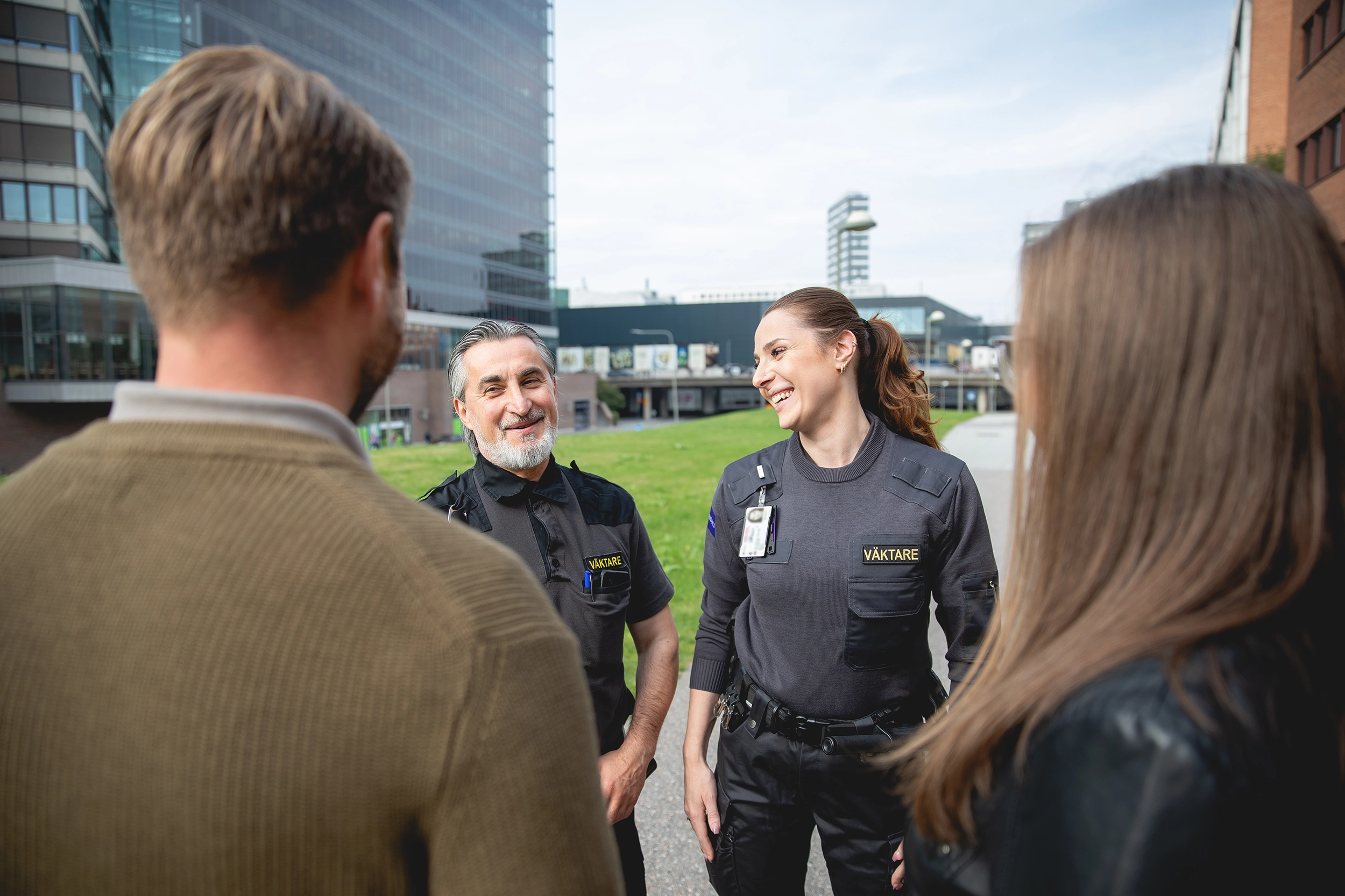 Två av Addicis väktare och två civila personer utanför Kista centrum.