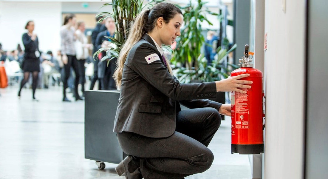 Addicis medarbetare kontrollerar brandsläckare i kontorsmiljö