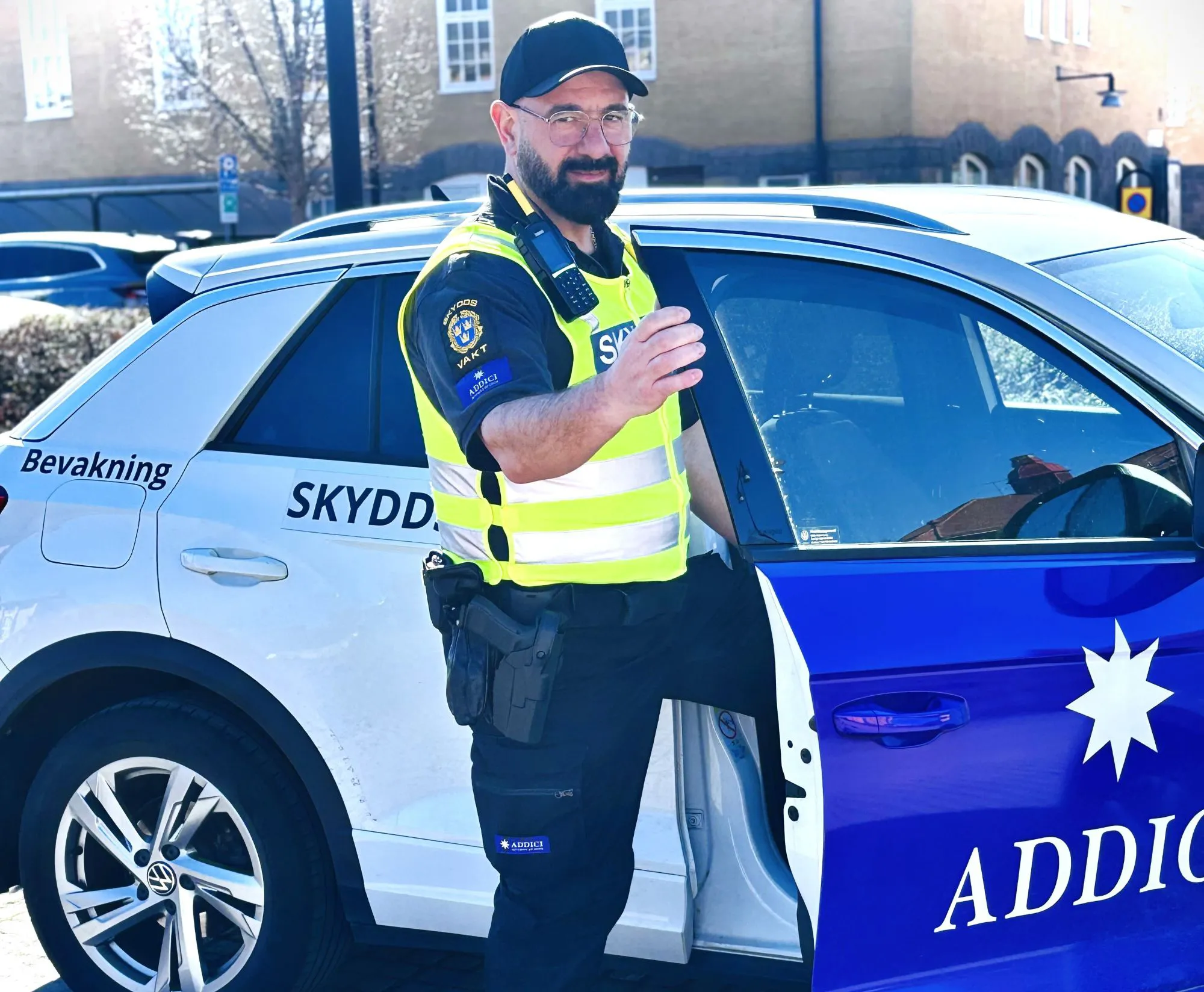 En av Addicis vakter iklädd varselväst kliver ur en Addicibil
