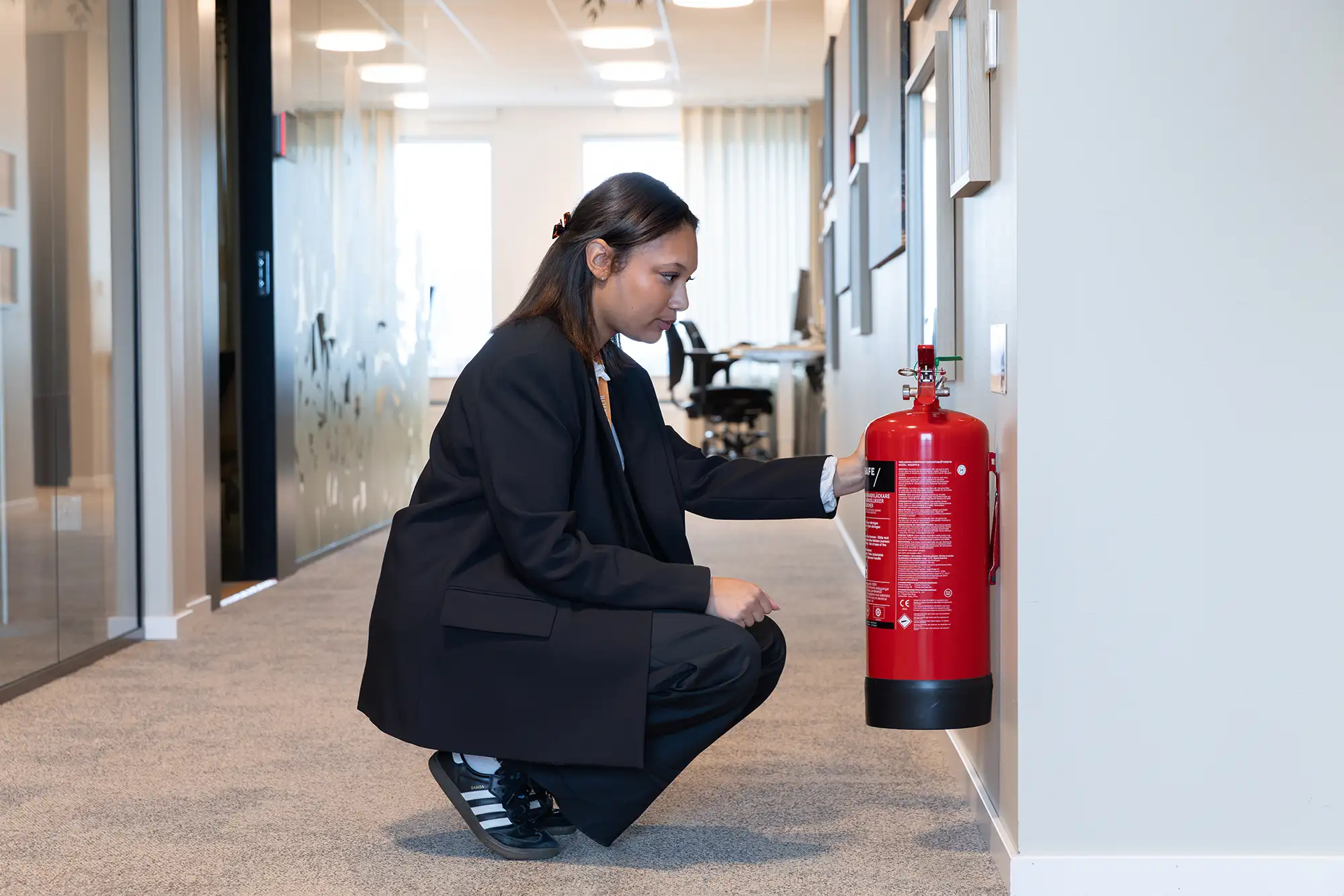 Addicis medarbetare kontrollerar brandsläckare i kontorsmiljö