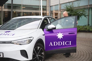 Väktare på Addici som står vid bil